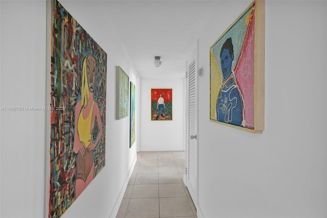 corridor featuring light tile patterned floors and baseboards