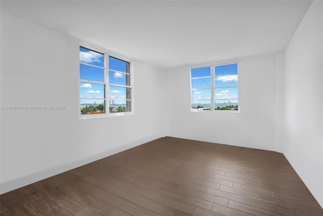 unfurnished room featuring dark wood finished floors and a textured ceiling