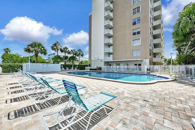 community pool with fence and a patio