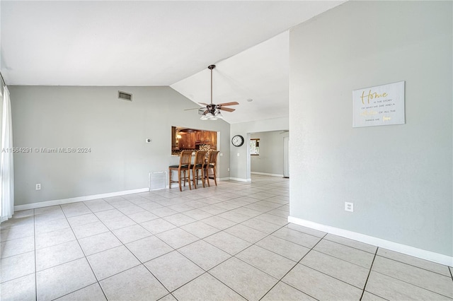 unfurnished living room with light tile patterned floors, vaulted ceiling, and ceiling fan