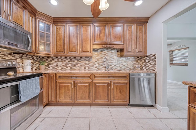 kitchen featuring decorative backsplash, appliances with stainless steel finishes, light tile patterned flooring, and sink