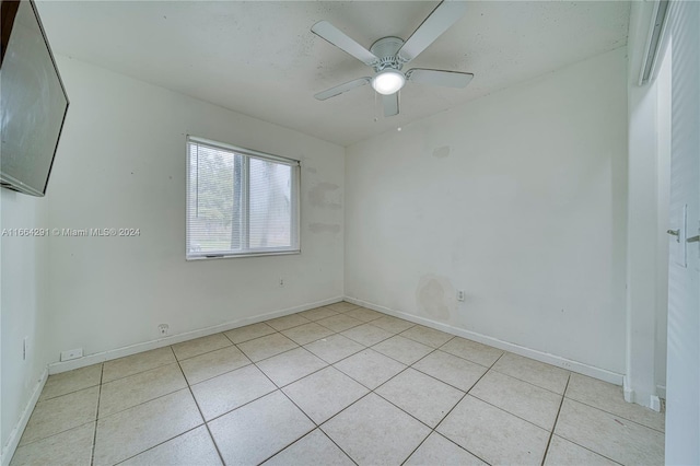 empty room with ceiling fan and light tile patterned flooring