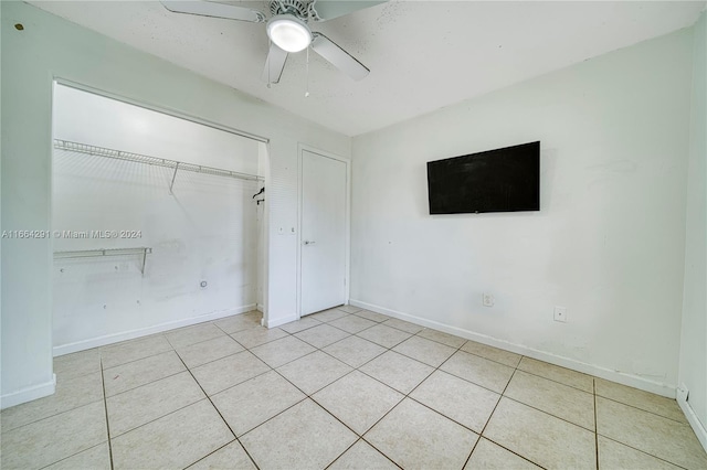 unfurnished bedroom featuring a closet, ceiling fan, and light tile patterned floors