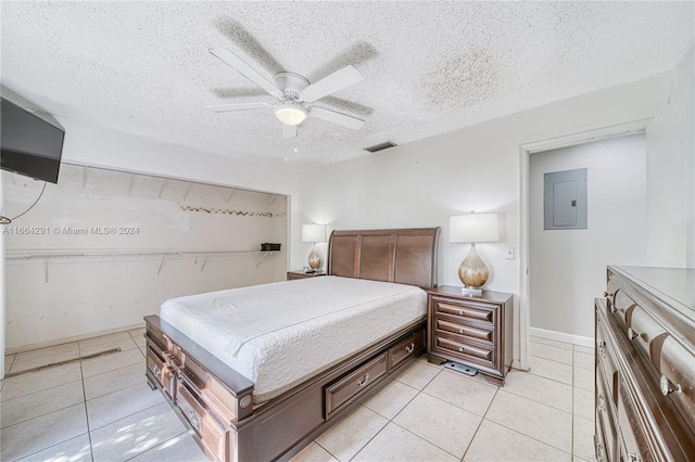 tiled bedroom featuring ceiling fan, electric panel, and a textured ceiling