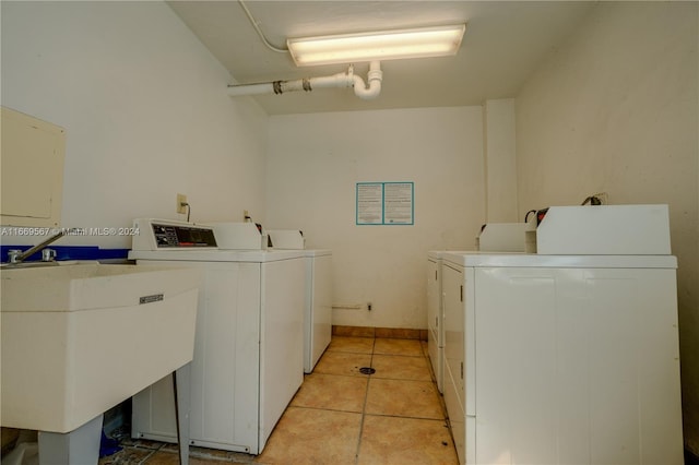 washroom with washer and clothes dryer, light tile patterned flooring, and sink