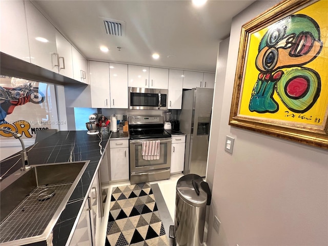 kitchen featuring appliances with stainless steel finishes, sink, and white cabinets