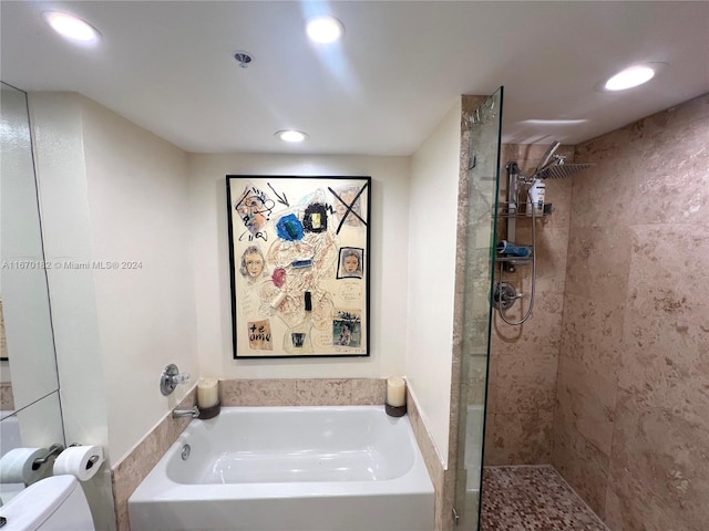 bathroom featuring shower with separate bathtub and toilet