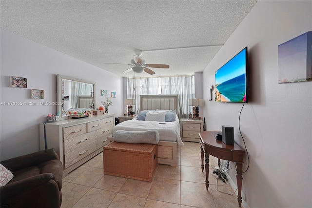 bedroom featuring a textured ceiling, light tile patterned floors, and ceiling fan