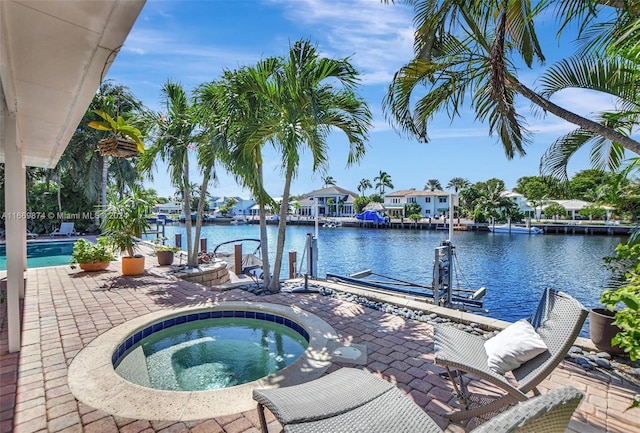 view of pool featuring a dock, an in ground hot tub, a water view, and a patio area