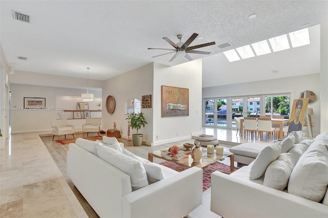 tiled living room featuring ceiling fan, a textured ceiling, and french doors