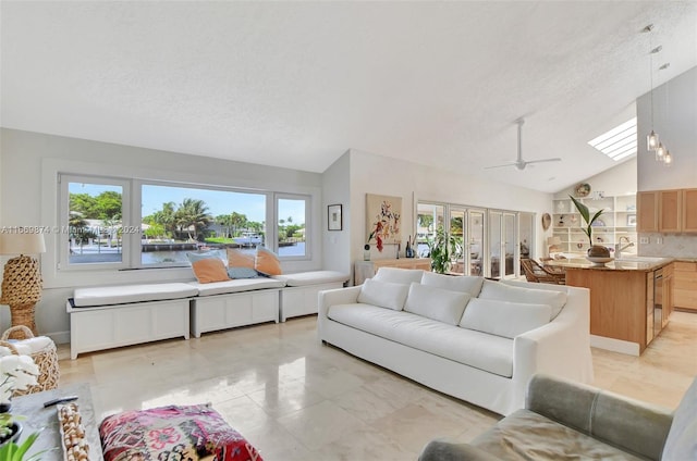 tiled living room with high vaulted ceiling, a textured ceiling, ceiling fan, and sink