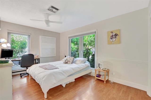 bedroom featuring multiple windows, light hardwood / wood-style floors, and ceiling fan