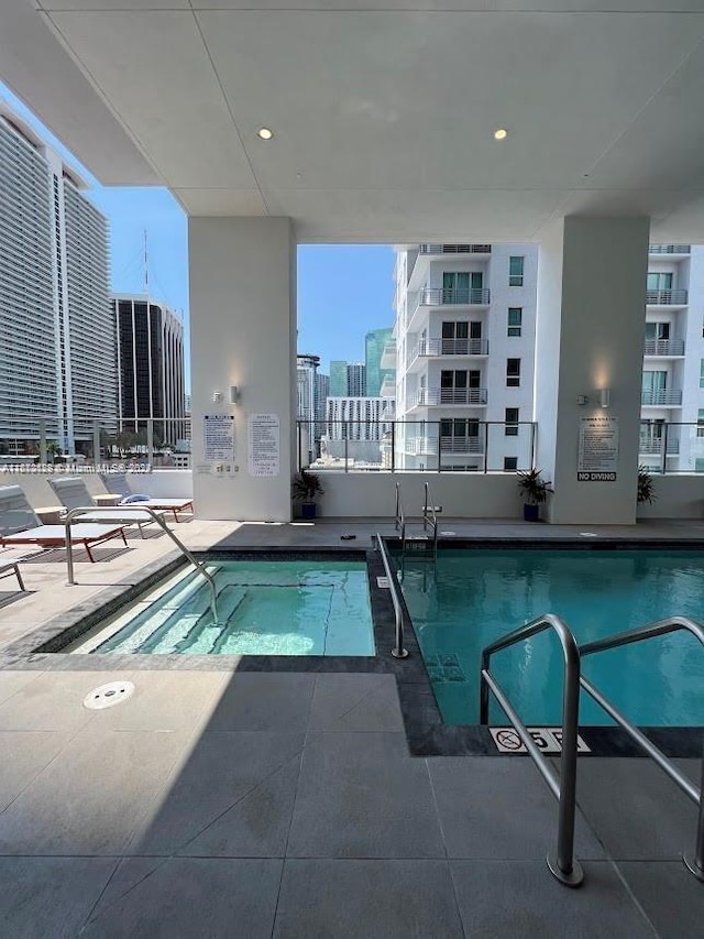 view of pool with a hot tub