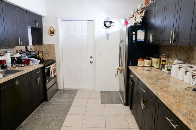 kitchen with light stone counters, light tile patterned flooring, appliances with stainless steel finishes, and tasteful backsplash