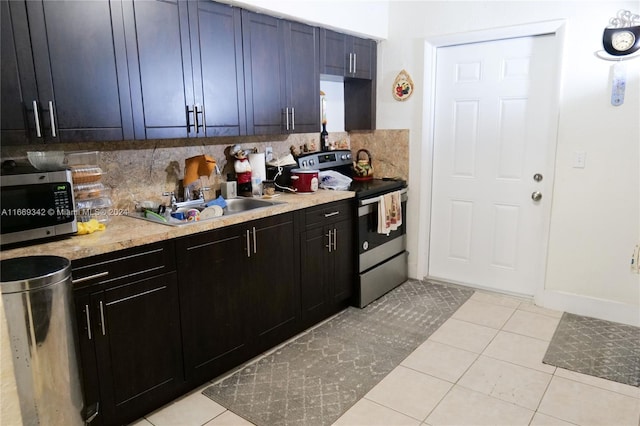 kitchen featuring sink, stainless steel appliances, light tile patterned floors, and tasteful backsplash