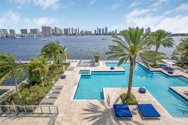 view of pool featuring a water view and a patio