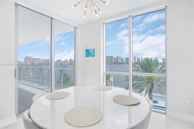 tiled dining space with a water view, floor to ceiling windows, and a notable chandelier