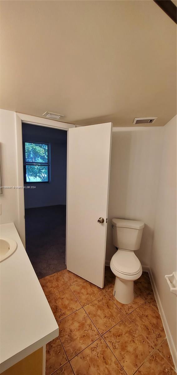 215 Lake Pointe Dr Unit 210, Oakland Park, FL 33309 - bathroom featuring tile patterned floors, visible vents, toilet, and vanity