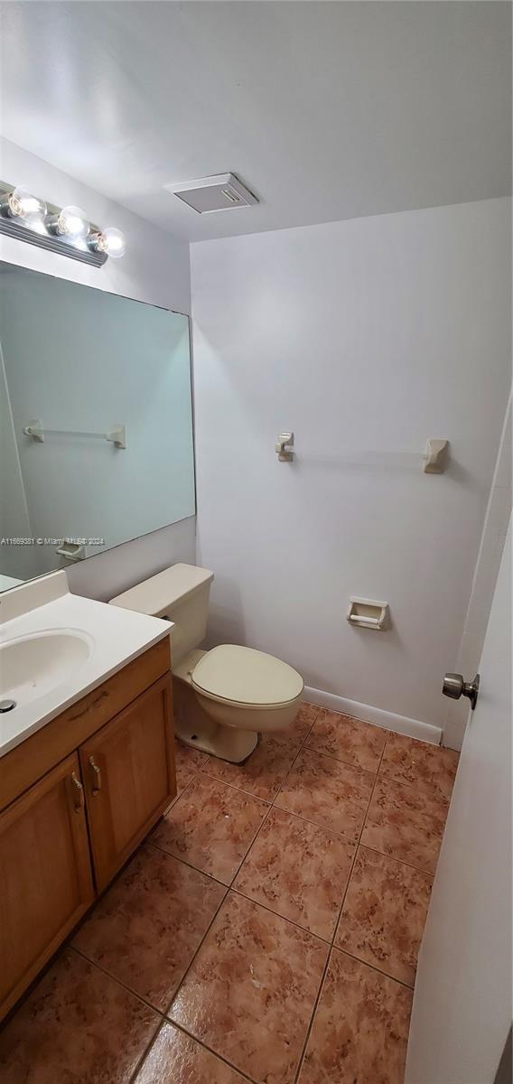 215 Lake Pointe Dr Unit 210, Oakland Park, FL 33309 - half bathroom featuring visible vents, toilet, tile patterned flooring, and vanity