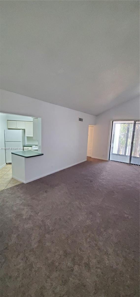 215 Lake Pointe Dr Unit 210, Oakland Park, FL 33309 - unfurnished living room with lofted ceiling, visible vents, and light carpet