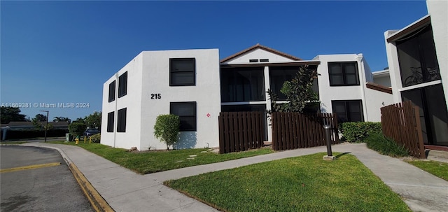 215 Lake Pointe Dr Unit 210, Oakland Park, FL 33309 - view of front of property with stucco siding, fence, and a front lawn