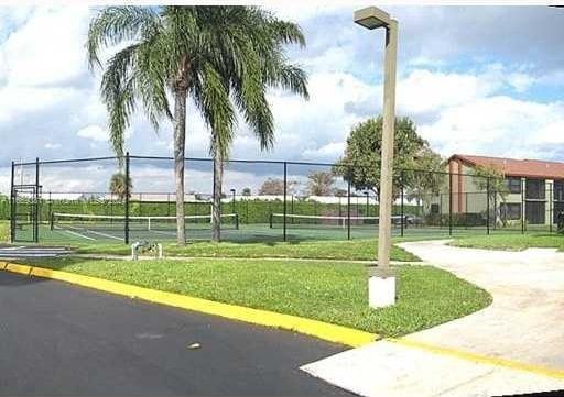 215 Lake Pointe Dr Unit 210, Oakland Park, FL 33309 - view of property's community featuring a yard, a tennis court, and fence