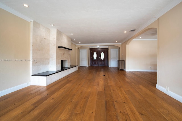 unfurnished living room featuring crown molding, a fireplace, and hardwood / wood-style floors