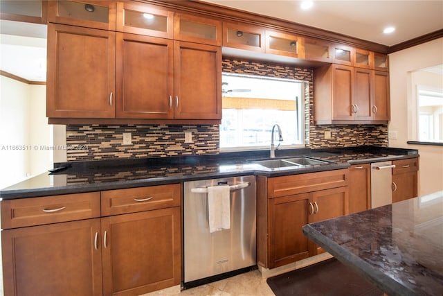 kitchen with dark stone countertops, ornamental molding, sink, and stainless steel dishwasher