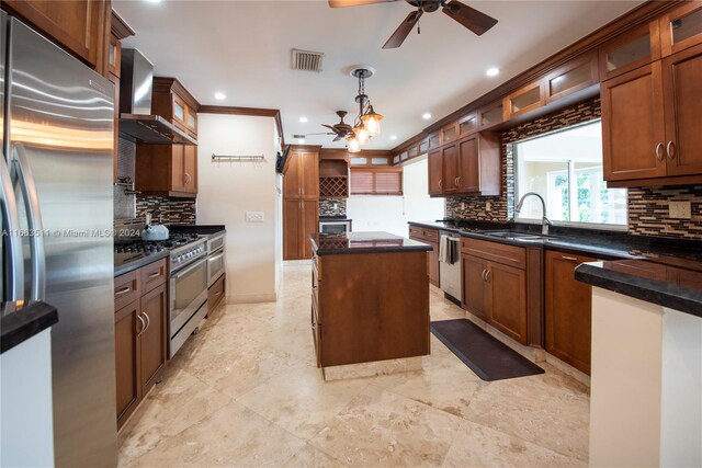 kitchen featuring wall chimney exhaust hood, tasteful backsplash, appliances with stainless steel finishes, and a center island