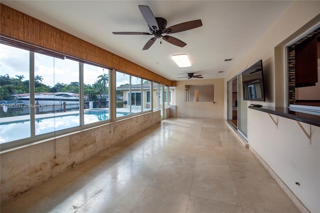 tiled spare room featuring ceiling fan