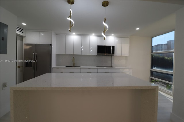 kitchen with hanging light fixtures, white cabinetry, sink, and stainless steel appliances