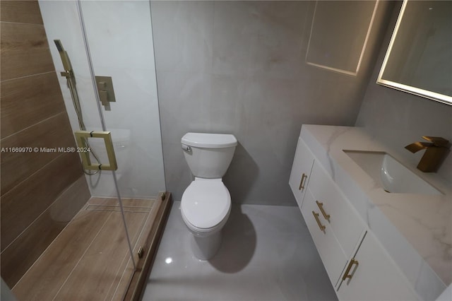 bathroom with vanity, tile walls, and toilet