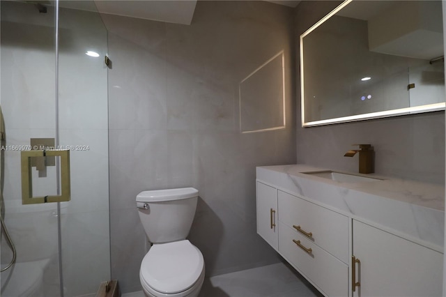 bathroom featuring tile walls, vanity, toilet, and an enclosed shower