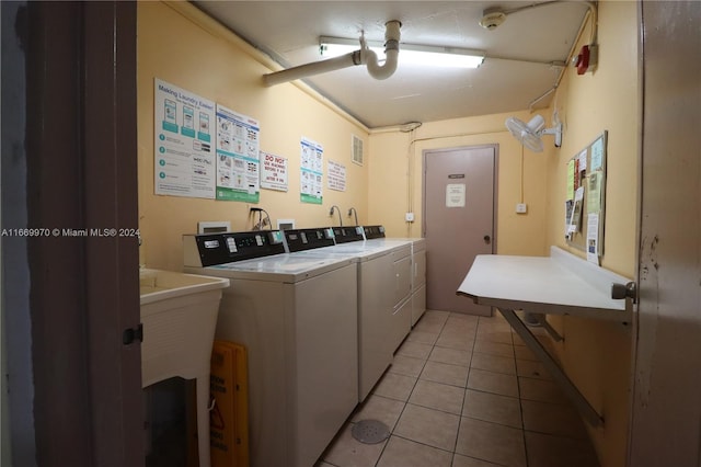 clothes washing area featuring separate washer and dryer and light tile patterned floors