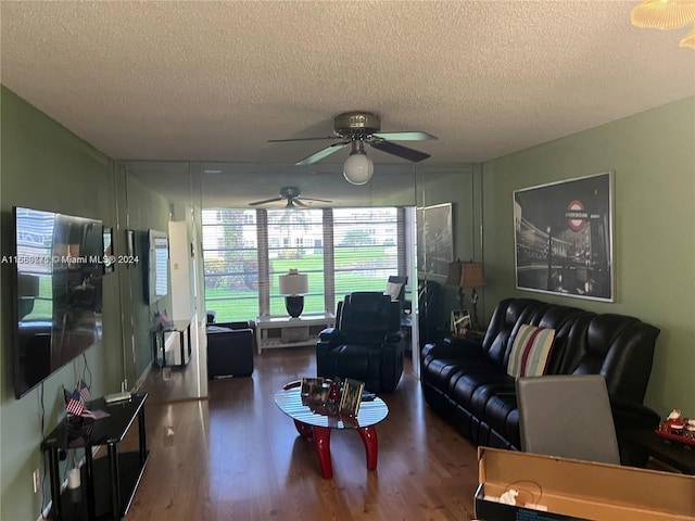 living room with ceiling fan, a textured ceiling, and dark hardwood / wood-style floors