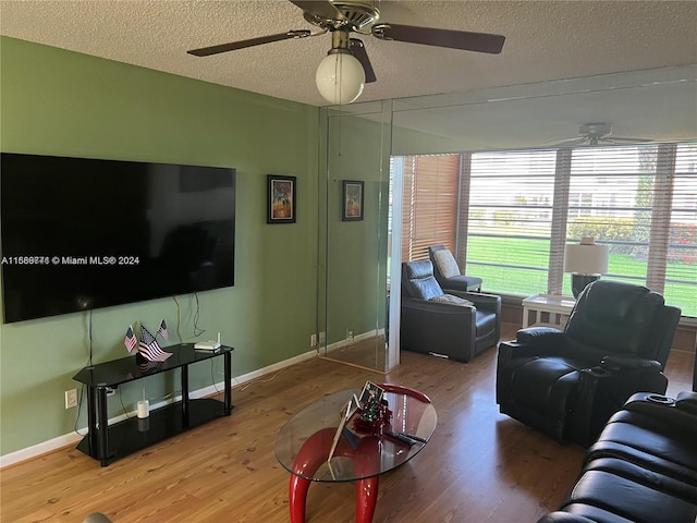 living room featuring ceiling fan, a textured ceiling, and hardwood / wood-style floors