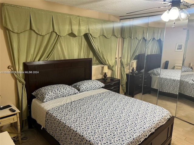 bedroom featuring a textured ceiling, light hardwood / wood-style floors, and ceiling fan