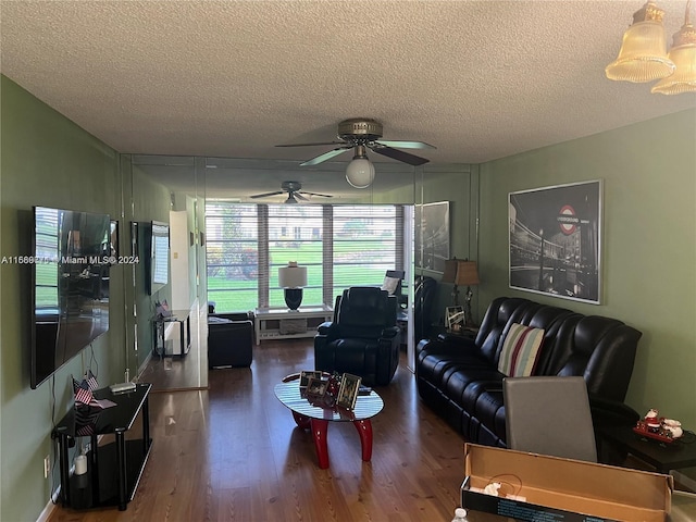 living room with a textured ceiling, ceiling fan, and dark hardwood / wood-style flooring