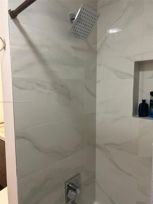 bathroom featuring vanity and tiled shower