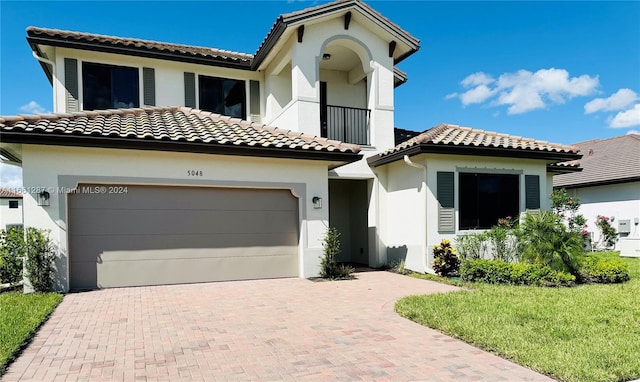 mediterranean / spanish home with a garage and a front lawn