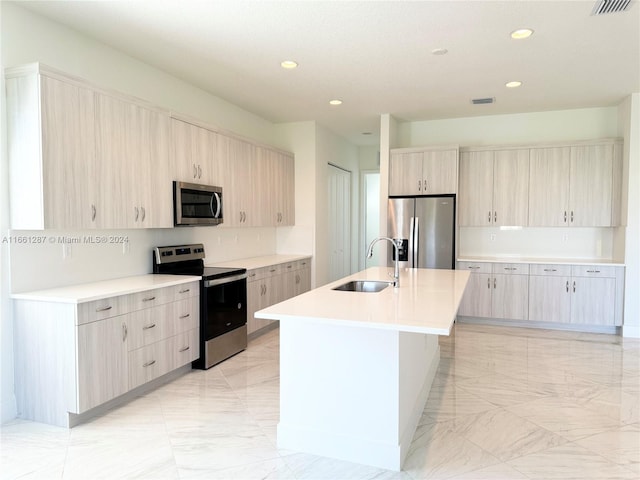 kitchen with light brown cabinetry, a kitchen island with sink, stainless steel appliances, and sink