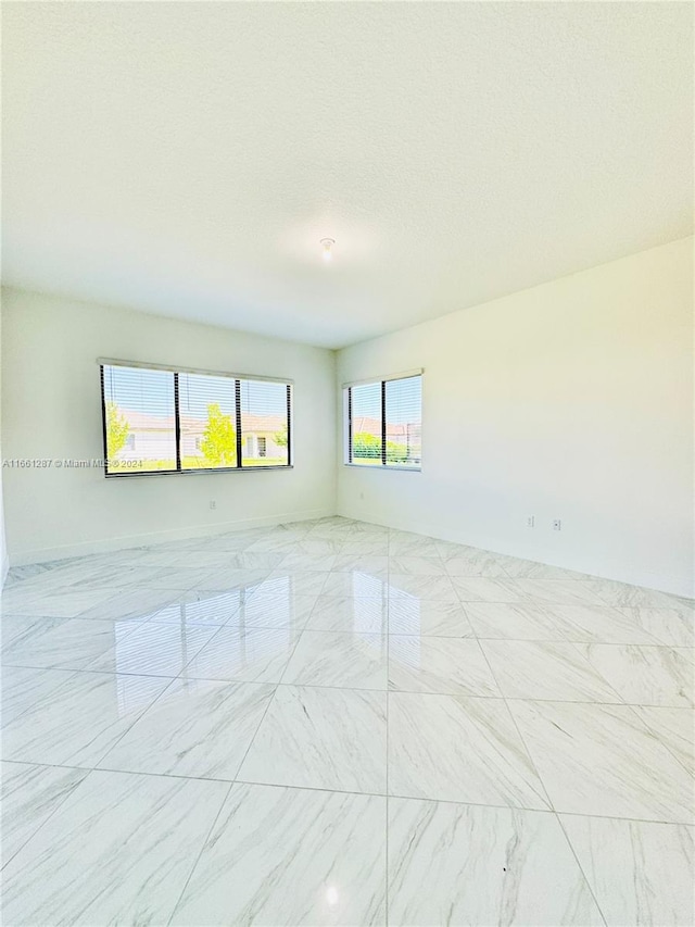 unfurnished room featuring a textured ceiling