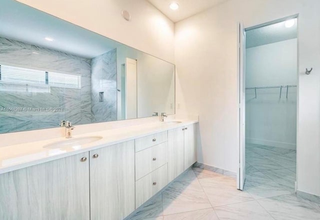 bathroom featuring a tile shower and vanity