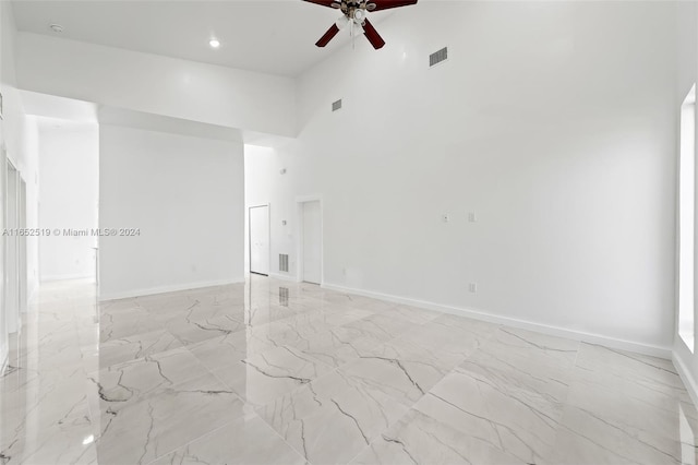 empty room with a high ceiling and ceiling fan