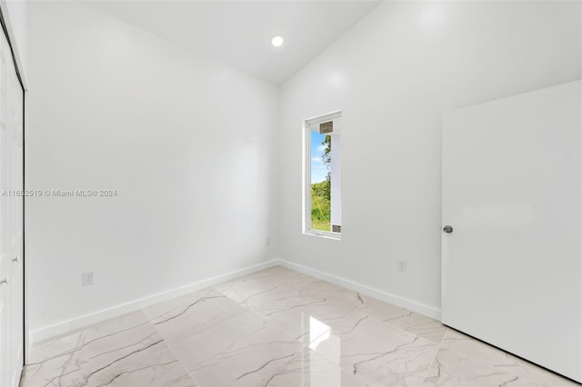 unfurnished room with vaulted ceiling