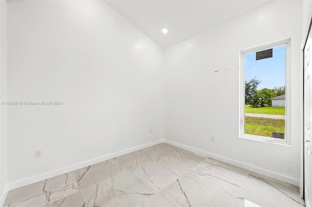 empty room featuring lofted ceiling