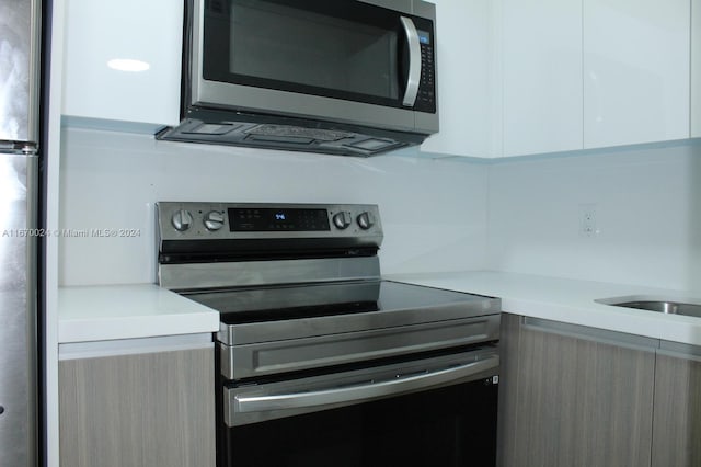 kitchen with appliances with stainless steel finishes and white cabinetry