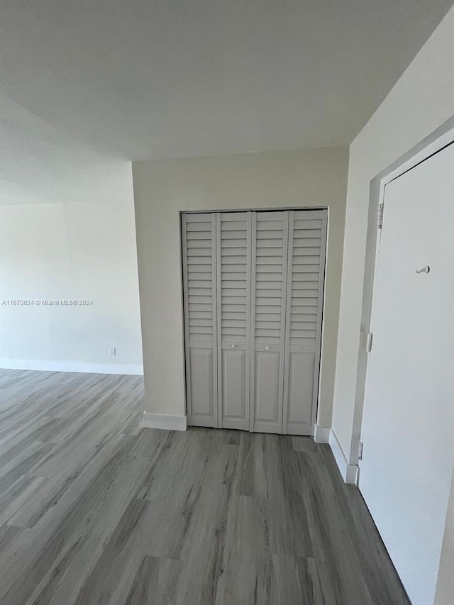 unfurnished bedroom with wood-type flooring and a closet