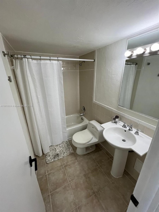 bathroom with tile patterned flooring, shower / bathtub combination with curtain, and toilet