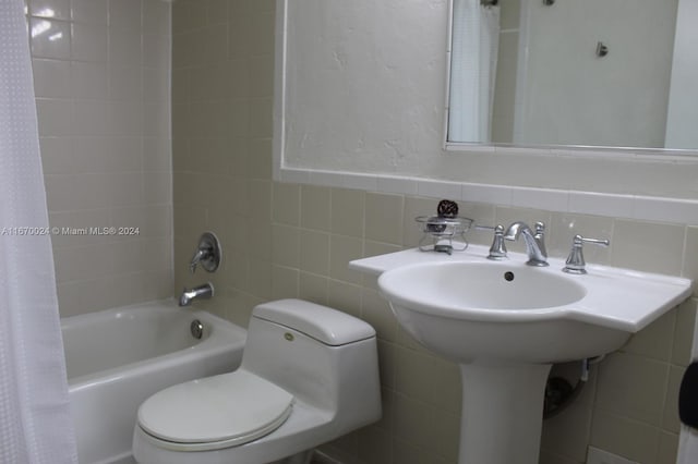 bathroom with shower / tub combo with curtain, tile walls, and toilet